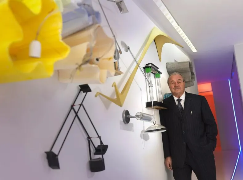 Эрнесто Джизмонди на фоне культовых светильников Artemide Основатель бренда Artemide Эрнесто Джизмонди